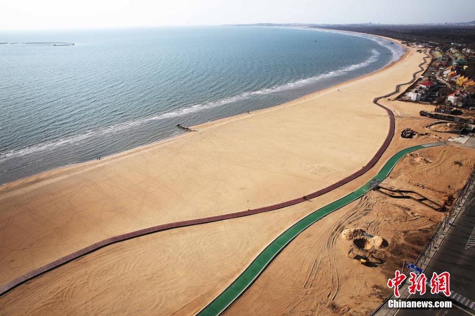 3月13日，秦皇島萬(wàn)米臨海沙灘木棧道。據了解，該木棧道全長(cháng)約4200米，與北戴河區原有的7500米木棧道對接后全線(xiàn)總長(cháng)度1.17萬(wàn)米，整個(gè)木棧道東起秦皇島體育基地游船碼頭，西至北戴河濕地公園，呈波浪形蜿蜒10.4公里海岸線(xiàn)。 中新社發(fā) 曹建雄 攝 CNSPHOTO