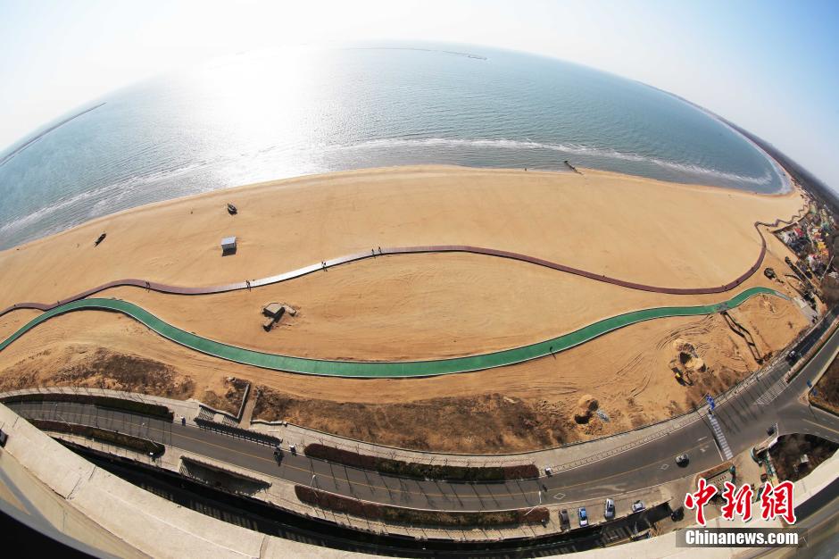 3月13日，秦皇島萬(wàn)米臨海沙灘木棧道。據了解，該木棧道全長(cháng)約4200米，與北戴河區原有的7500米木棧道對接后全線(xiàn)總長(cháng)度1.17萬(wàn)米，整個(gè)木棧道東起秦皇島體育基地游船碼頭，西至北戴河濕地公園，呈波浪形蜿蜒10.4公里海岸線(xiàn)。 中新社發(fā) 曹建雄 攝 CNSPHOTO